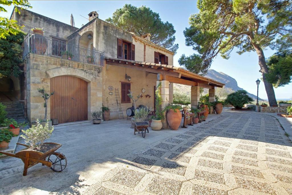 uma casa com um pátio com vasos de plantas em Poggio di mare em Castelluzzo