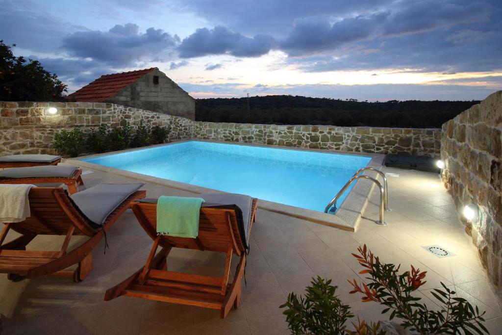 契利比的住宿－Villa Bellezza，一个带两把椅子和一张桌子的大型游泳池