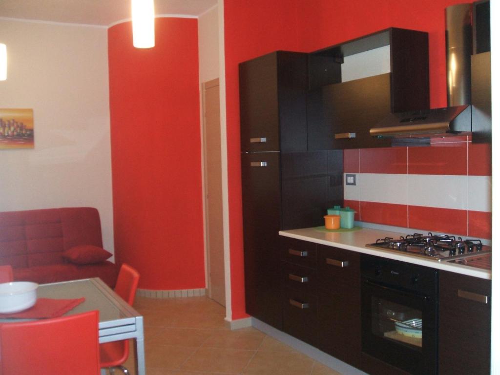 una cucina con armadi neri e parete rossa di Casa Vacanze Letizia a Lercara Friddi