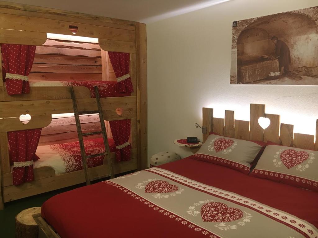 a bedroom with a bed next to a bunk bed at Atmosphere di montagna in Vermiglio