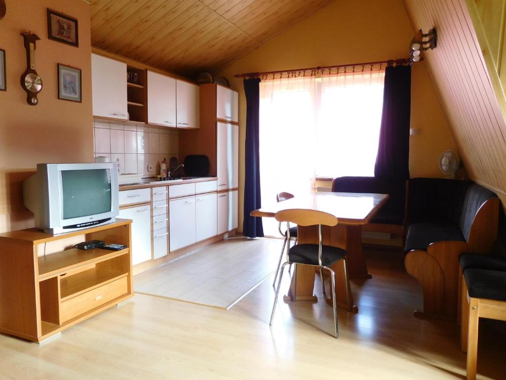 een kleine woonkamer met een televisie en een keuken bij Willa pod piórem in Szczyrk