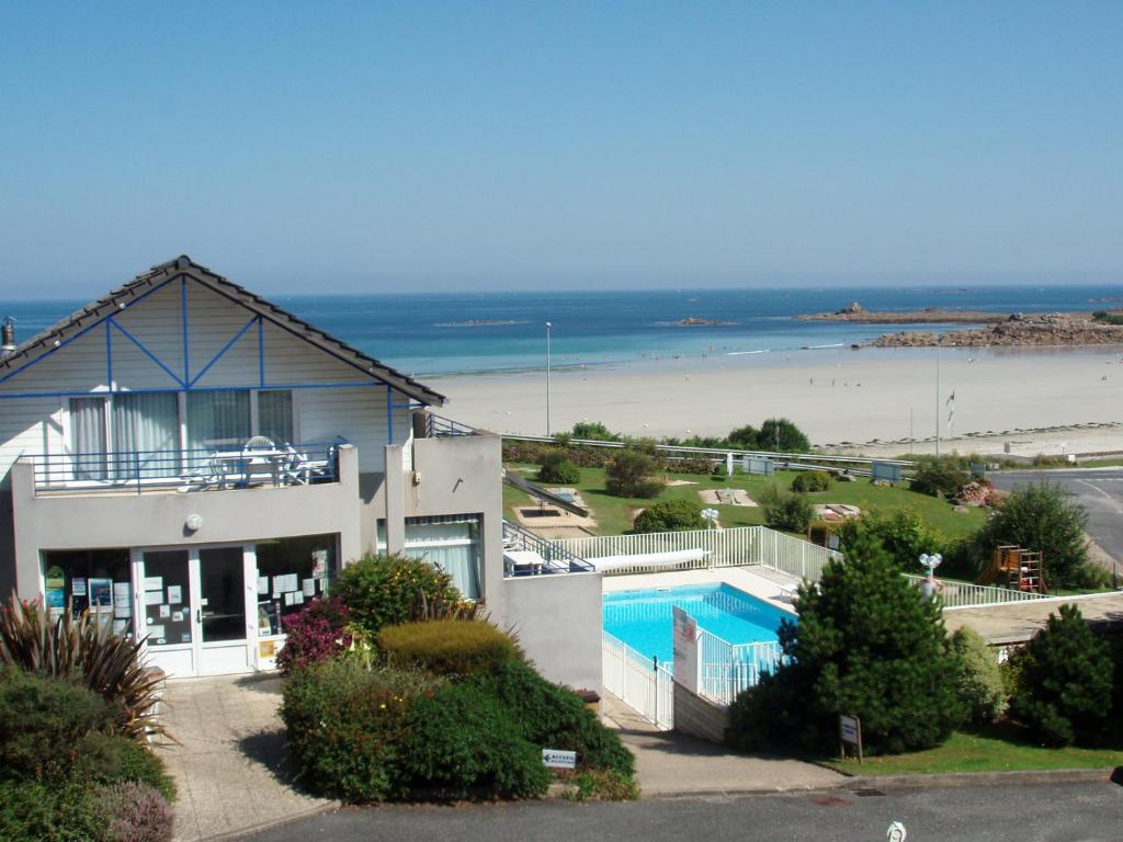 a house with a swimming pool next to a beach at Les Terrasses de la plage de Trestel in Trévou-Tréguignec