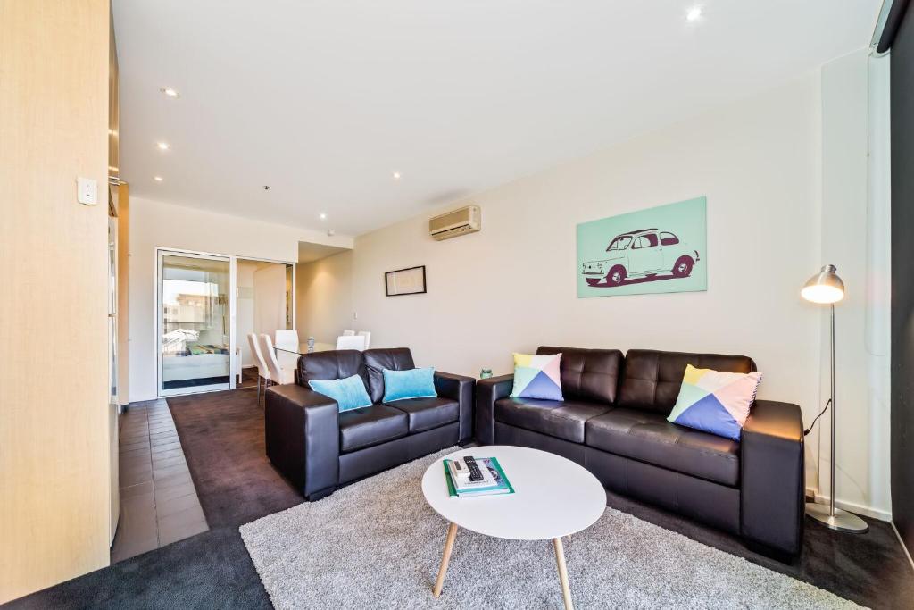 a living room with a couch and a table at York Apartments in Adelaide