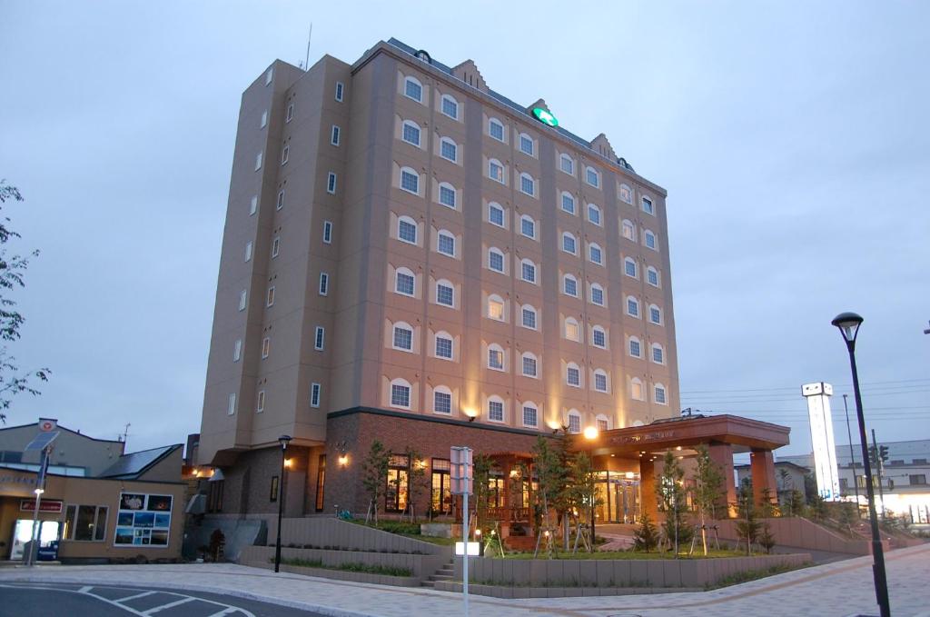 un gran edificio marrón con una calle delante en Route Inn Grantia Shiretoko Shari Ekimae, en Shari