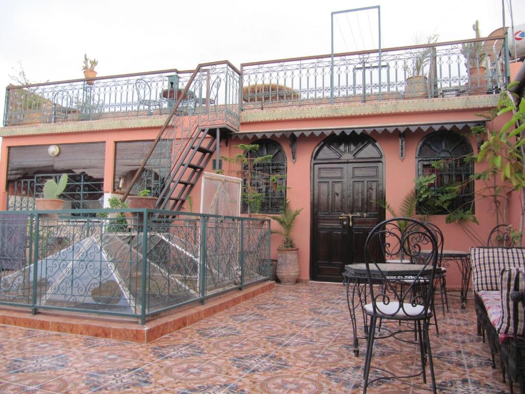 een patio met een tafel en stoelen voor een huis bij Sindi Sud in Marrakesh