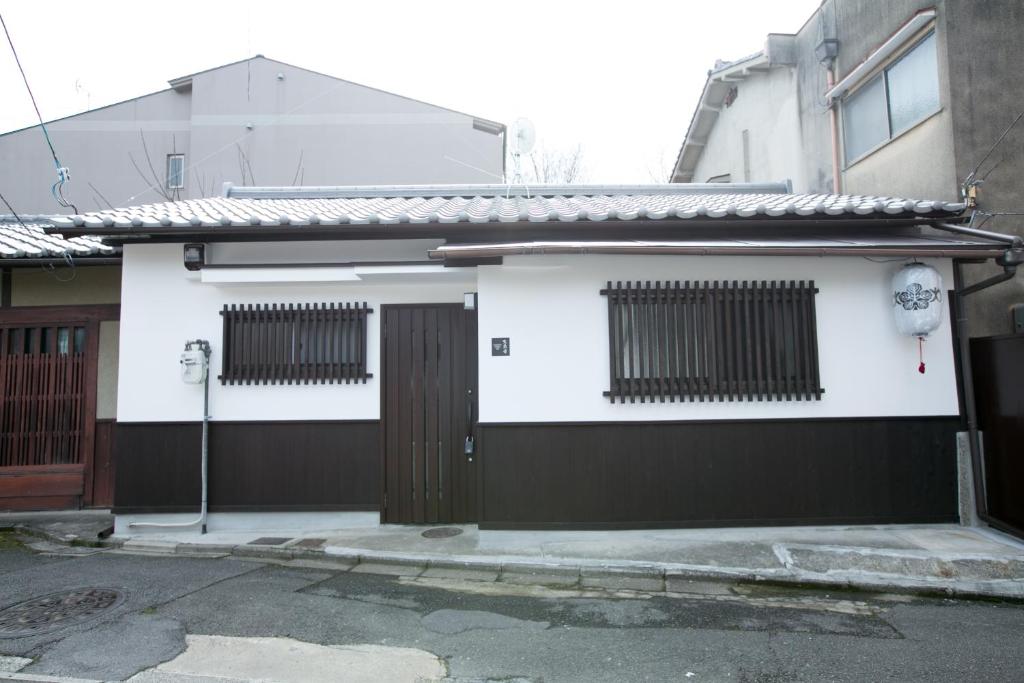 a white house with a black and white garage at Daisenji Lodge Ing 墨 地下鉄鞍馬口駅から徒歩1分 in Kyoto