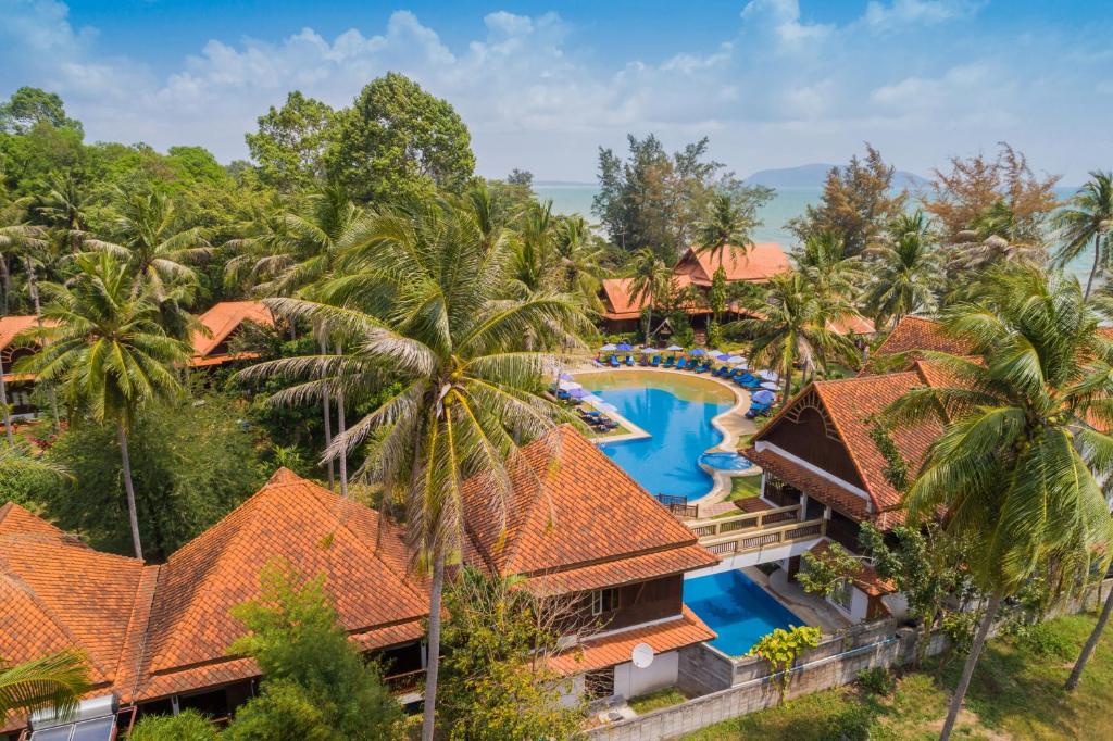 an aerial view of a resort with a pool and palm trees at Coral Hotel Bangsaphan in Bang Saphan