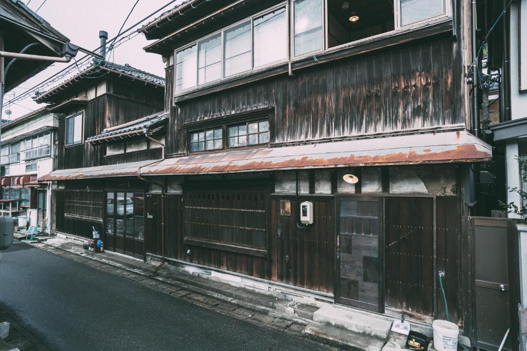 un vieux bâtiment en bois sur le côté d'une rue dans l'établissement Nari Nuttari Nari, à Niigata