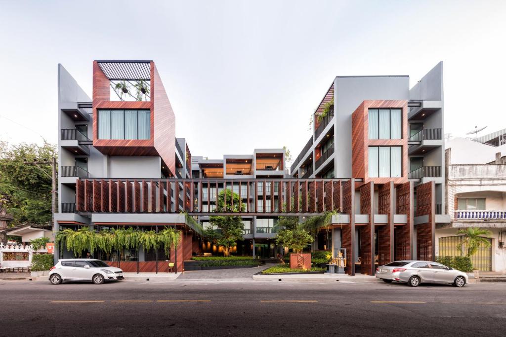 two cars parked in front of a building at The Habita Hatyai in Hat Yai