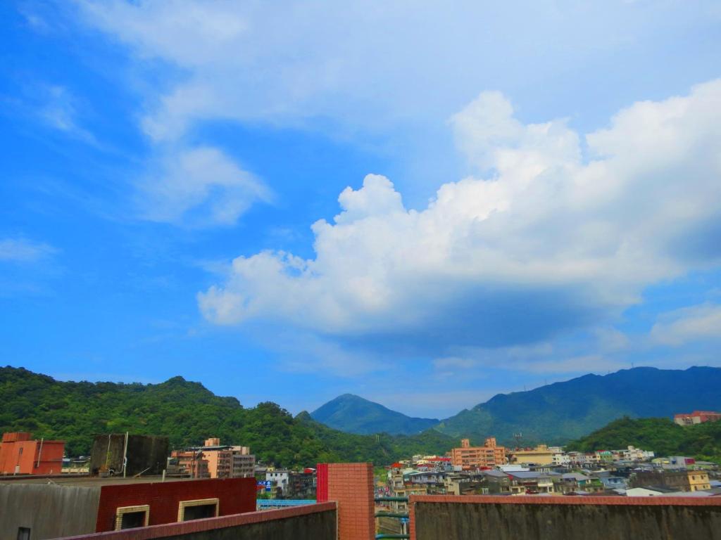 uma vista para uma cidade com montanhas ao fundo em eZ Stay Juifen(Ruifang Station) em Ruifang