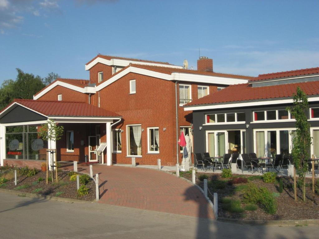 a brick building with chairs and tables in front of it at Hotel Eleganz in Rustow