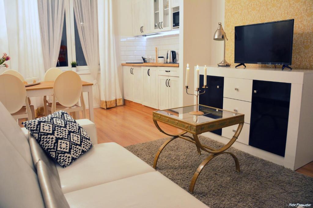 a living room with a white couch and a table with candles at Gold Box Apartament in Gdańsk
