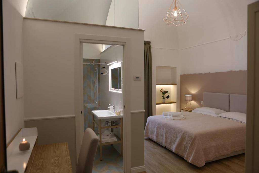 um quarto com uma cama e uma casa de banho com um lavatório em Novella 55 em Gravina in Puglia