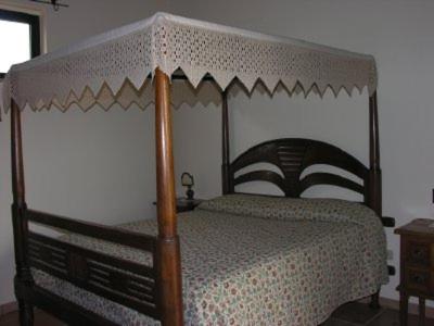 a bedroom with a bed with a wooden canopy at Tenuta Tannoja in Andria