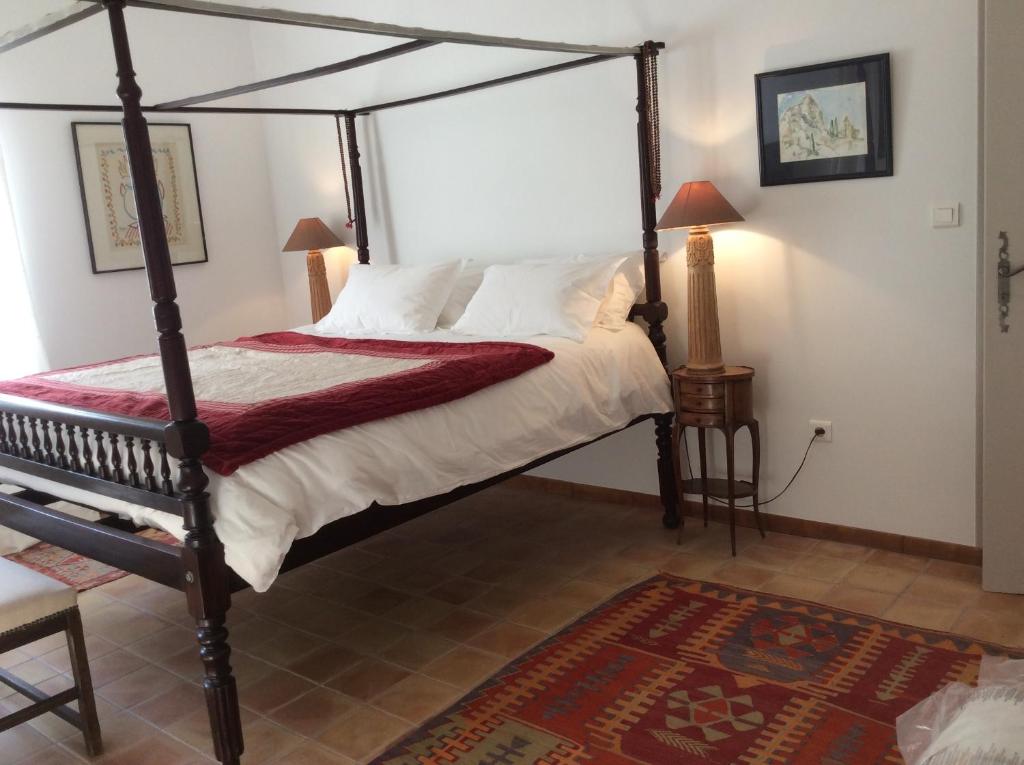 a bedroom with a canopy bed and a rug at Atelier Soleil in Moustiers-Sainte-Marie