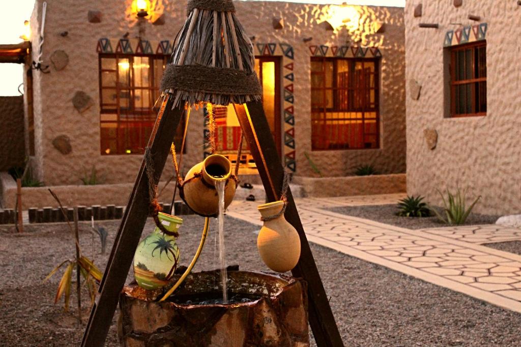 a group of vases on a stand in front of a house at Al Reem Chalet in Al Ashkharah