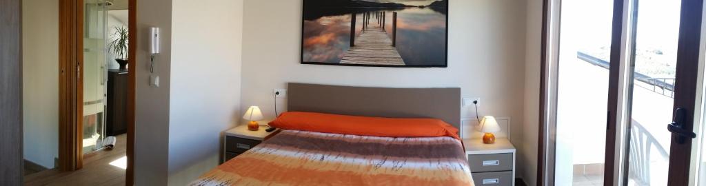 sypialnia z łóżkiem z pomarańczowym kocem w obiekcie Casa Txema w mieście Lorca