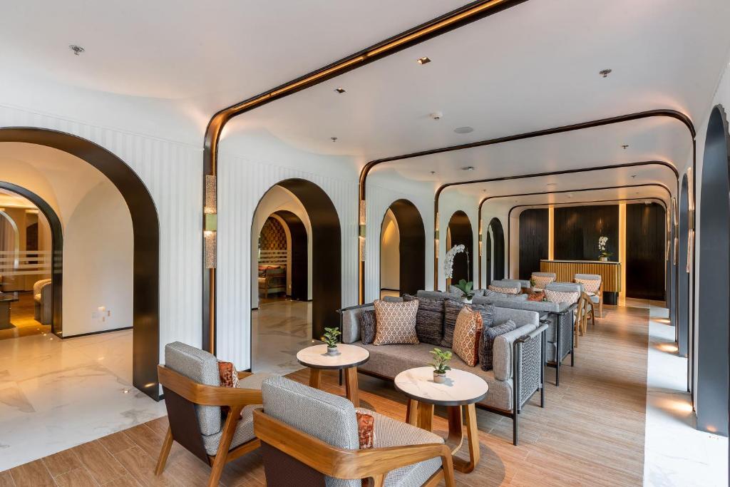 A spacious waiting lounge arranged around sofas and low round tables.