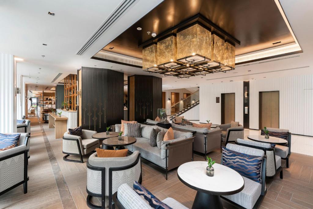 A large contemporary lobby lounge beneath a statement chandelier.