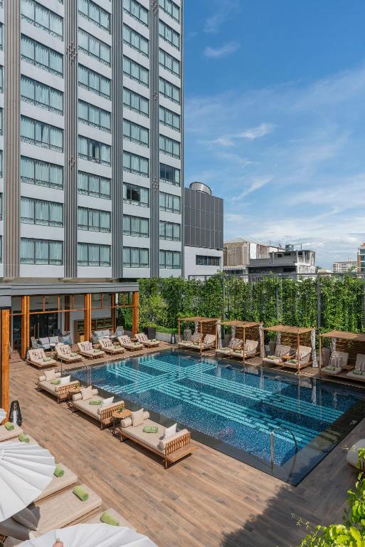 A wide rooftop-style pool deck with city buildings rising around it.