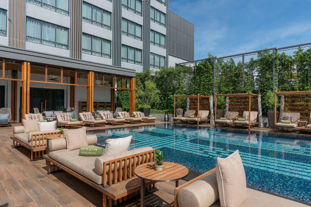 A close poolside view focused on loungers, cabanas, and the surrounding hotel buildings.