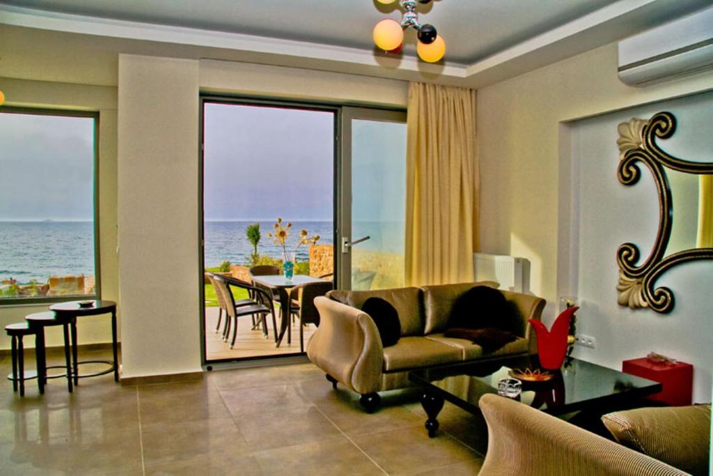 a living room with a couch and a table at Sea View Beachfront Villa Peri in Gouves