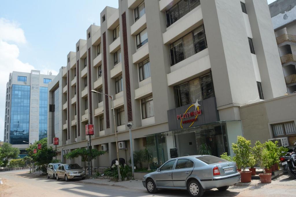 un edificio con coches estacionados frente a él en Hotel Platinum Residency, en Ahmedabad