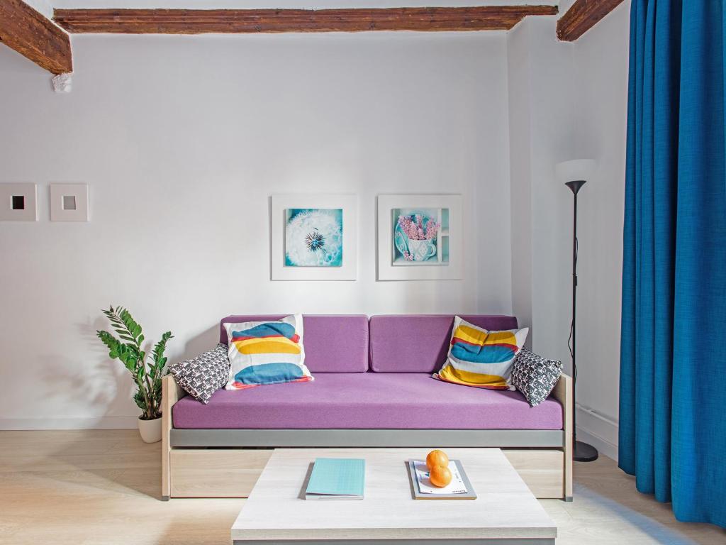バレンシアにあるUNIK. Apartments Valenciaのリビングルーム(紫色のソファ、テーブル付)