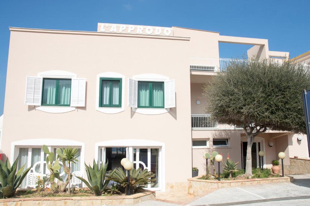 a large white building with green shutters at L'Approdo di Angelino in Pizzolungo