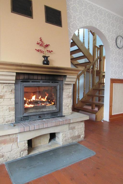 a fireplace in a living room with a staircase at Arina Holiday House in Nasva