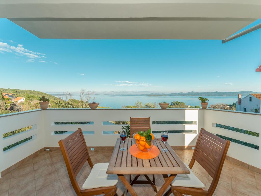 a table and chairs on a balcony with a view of the ocean at Holiday house Mareta, Sea View in Dragove