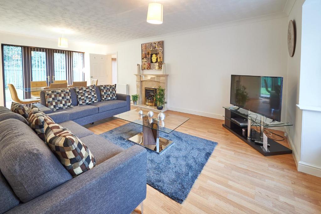 a living room with a couch and a television at ShortstayMK Northleigh House spacious home 6 bedrooms 5 bathrooms BT sports and Sky in Milton Keynes
