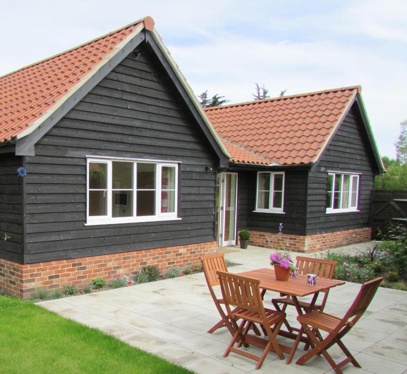 a house with a table and chairs in front of it at 1 Suffolk Cottage in Aldeburgh