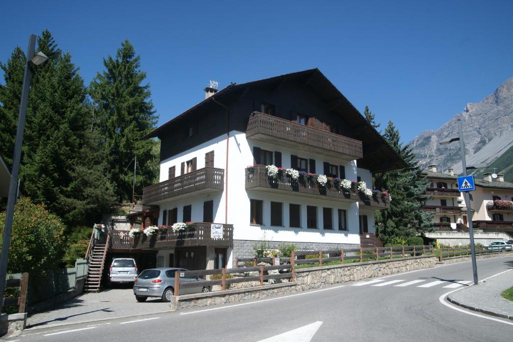 ein großes weißes Gebäude mit Balkon auf einer Straße in der Unterkunft Chalet dell'Ermellino in Bormio