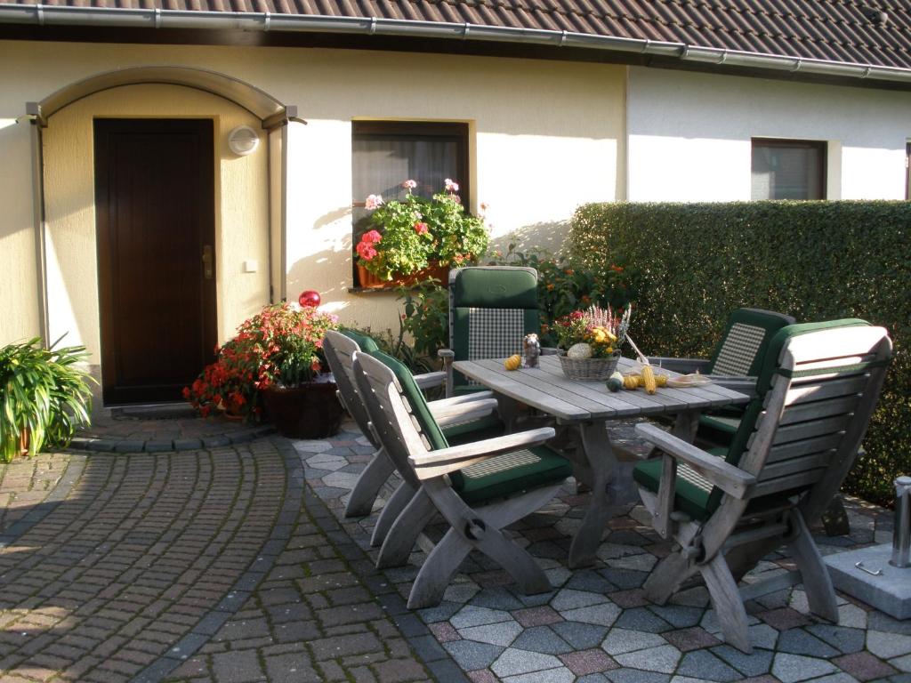 una mesa de madera y sillas frente a una casa en Ferienwohnung Gliese, en Beeskow
