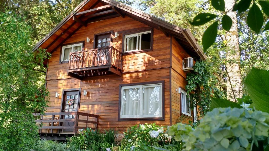 Una casa de madera con un balcón en un lateral. en Sobrado Estilo Alemão, en Canela