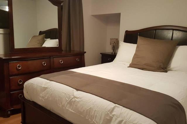 1 dormitorio con cama y espejo grande en 1-Bedroom Apartment Sweet #7 by Amazing Property Rentals en Gatineau