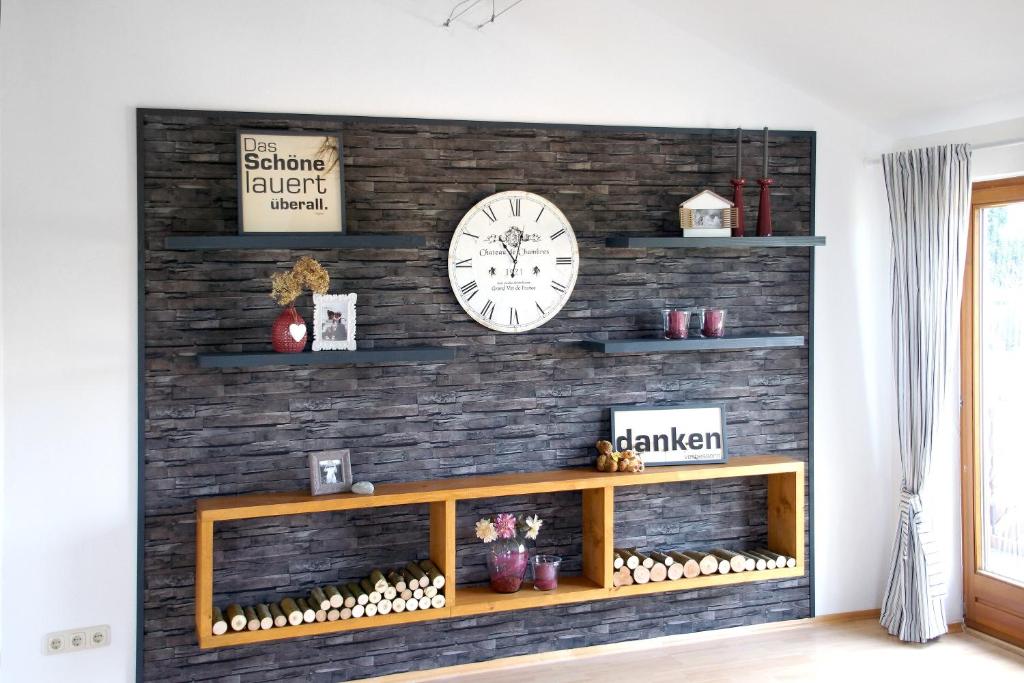 a living room with a brick wall with a clock at Ferien bei Maria in Alfter