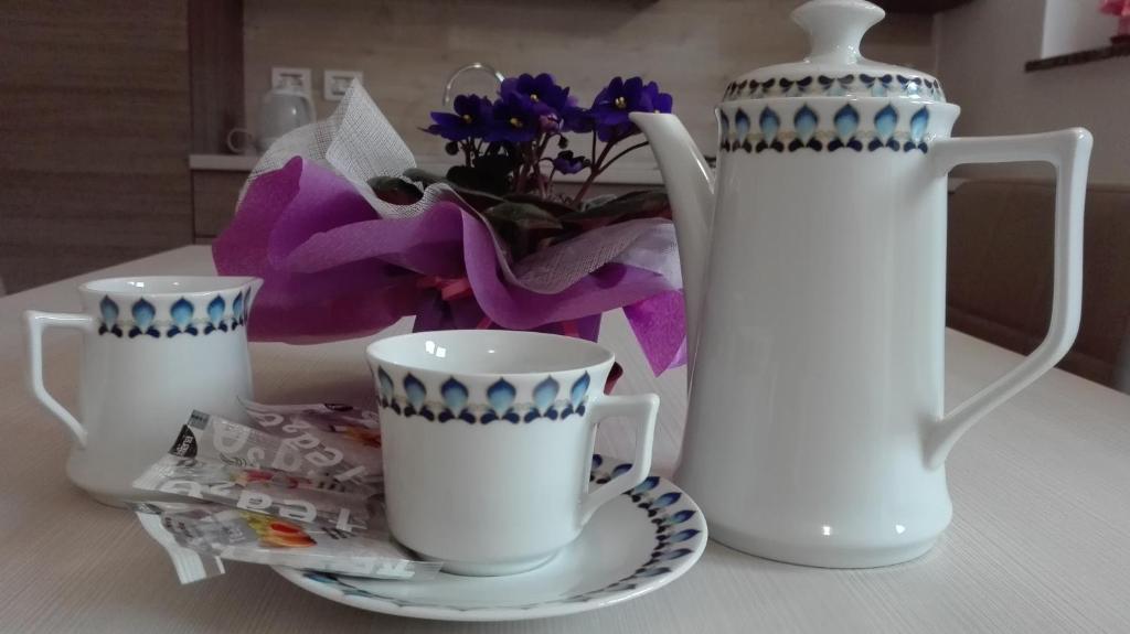 CastroにあるRocca sul Lagoの白花瓶とテーブルの上に置かれたカップ2杯