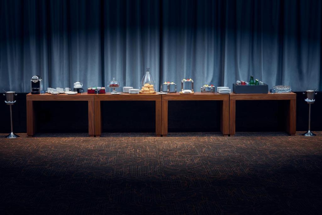 A long catered buffet table is arranged in front of a blue curtain.