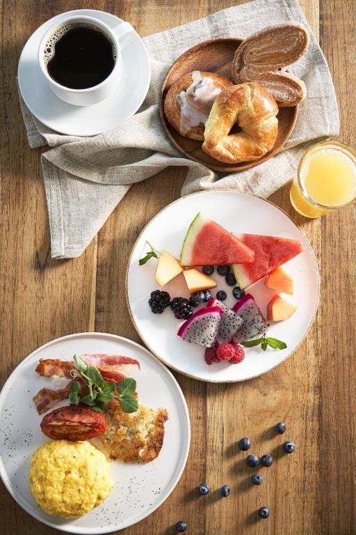 A generous breakfast spread with coffee, pastries, fruit and a hot savoury plate.