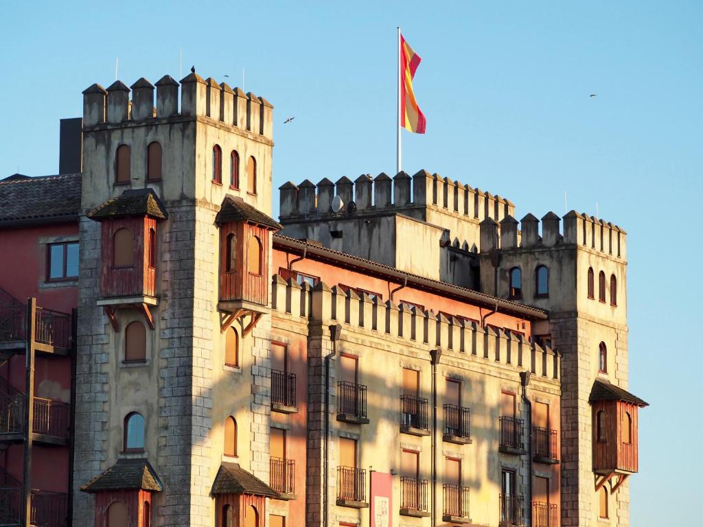 een kasteel met een vlag op een gebouw bij 4-Sterne Burghotel Castillo Alcazar, Europa-Park Freizeitpark & Erlebnis-Resort in Rust