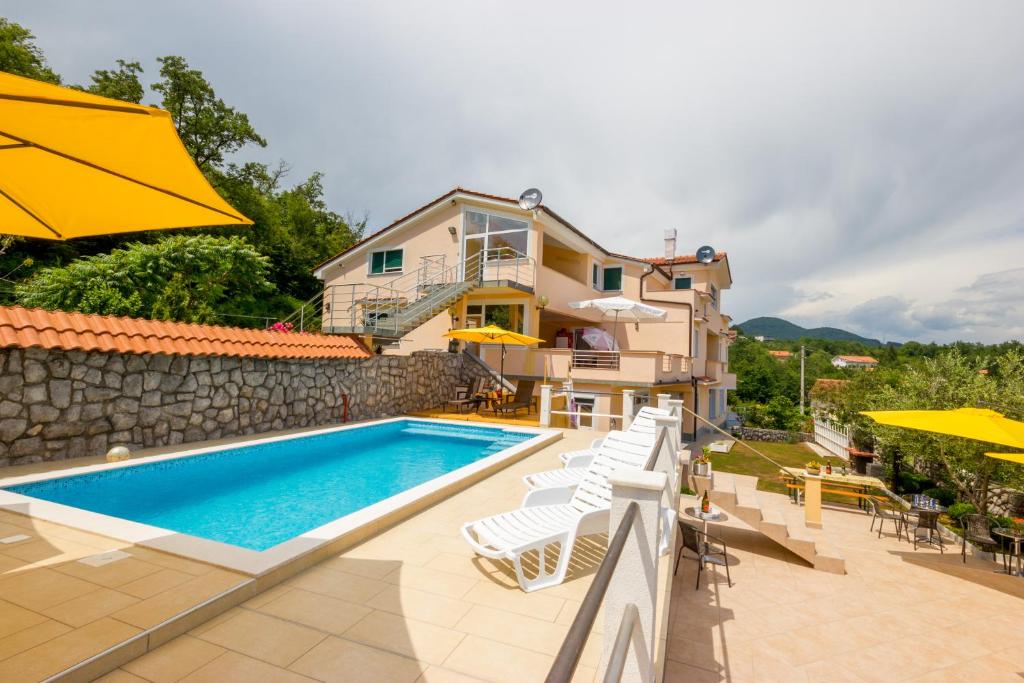 a villa with a swimming pool and a house at Apartment Eden in Veprinac