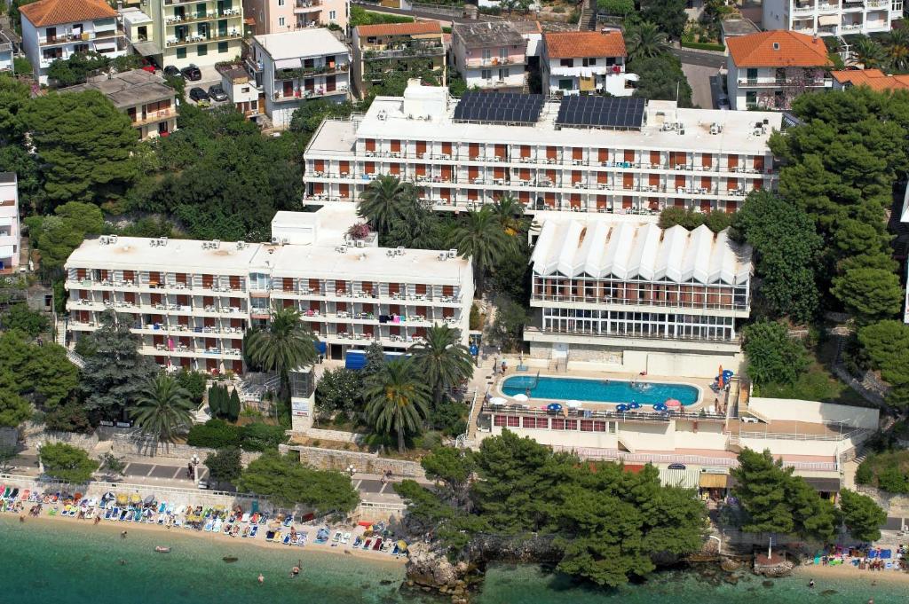 eine Luftansicht auf ein Hotel und einen Strand mit Gebäuden in der Unterkunft Hotel Aurora in Podgora