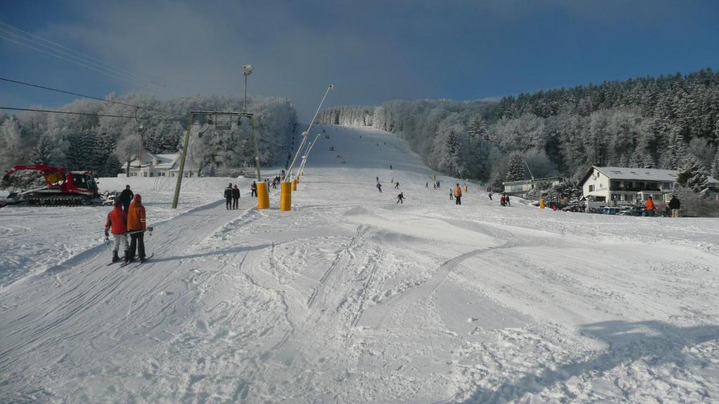 a group of people skiing down a snow covered slope at Kleines Ritz in Willingen