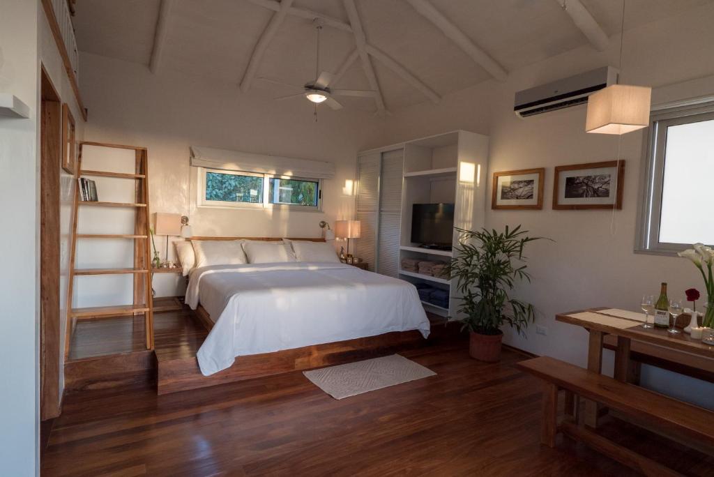 a bedroom with a large bed and a television at Moana Surf Resort in Nosara