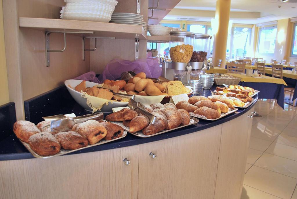 a buffet filled with different types of bread and pastries at Hotel Bologna in Lignano Sabbiadoro
