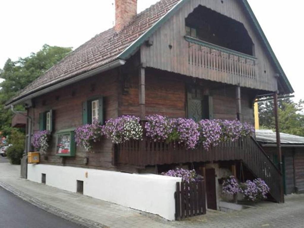 a wooden house with flowers on the side of it at Reginas Ferienhäuschen in Krieglach