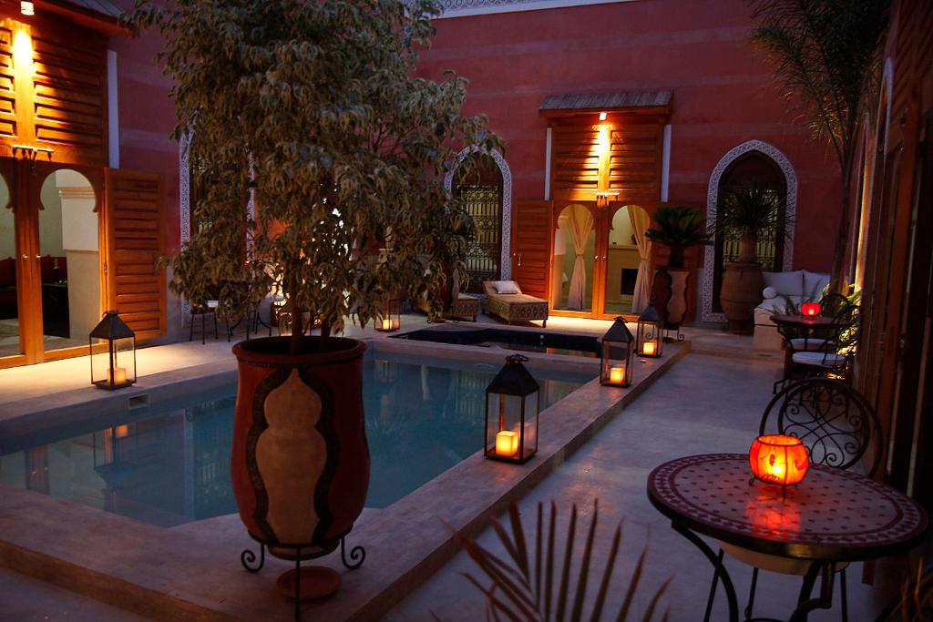 a house with a swimming pool with candles and lights at Riad Alili in Marrakech
