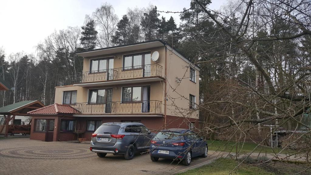 a house with two cars parked in front of it at U Zenona in Stegna